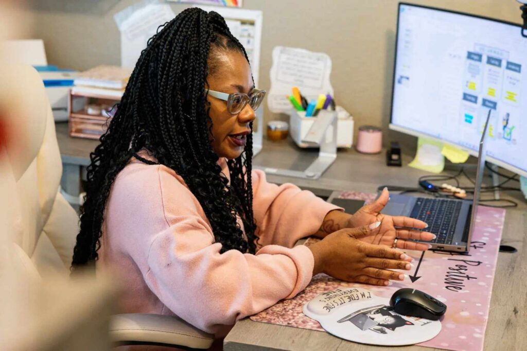 teacher sitting at desk hosting virtual class